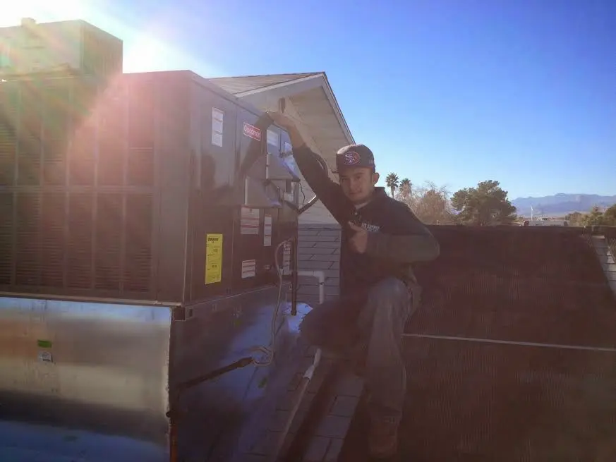 HVAC technician performing Air Duct Repair on a rooftop unit in Ferguson